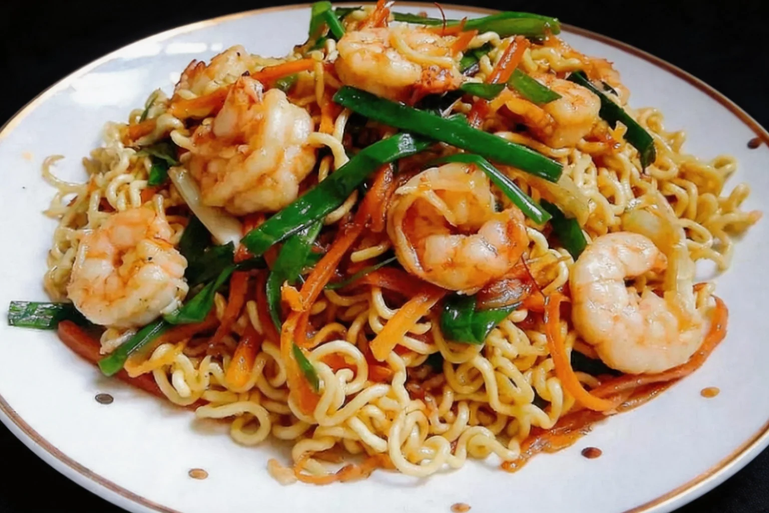 A33 Nouilles sautées aux crevettes, assiette blanche à liseré doré, fond sombre